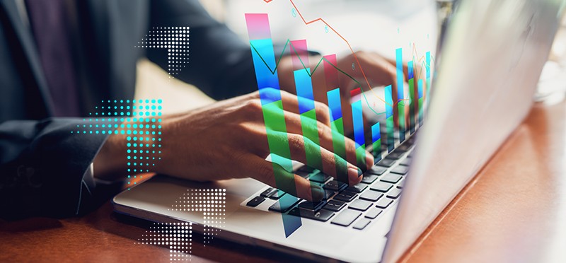 Hands typing on a laptop with a graphic of a bar chart rising from the keyboard